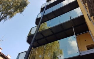 Moderní balkony s proskleným zábradlím Moderní přístavba vícepodlažních balkonů s proskleným zábradlím a ocelovou konstrukcí, realizace KOVKOM.