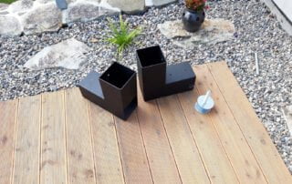 Ocelové držáky pro sloupky terasy Černé ocelové držáky na sloupky zábradlí či plotu, práškově lakované, na dřevěné terase.