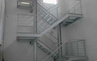 Ocelové schodiště s kovovým zábradlím Robustní ocelové schodiště s kovovým zábradlím pro vnitřní prostory, zakázková výroba a instalace KOVKOM.