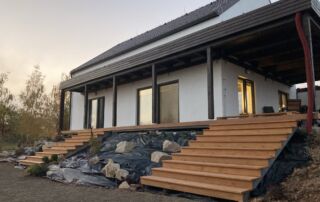 Zakázkové dřevěné schody a terasa s přístřeškem na kovové konstrukci u moderního domu, realizace KOVKOM.