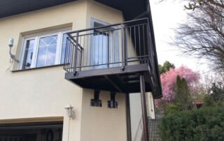 Nový kovový balkon se zábradlím na rodinném domě od KOVKOM. Zakázková kovovýroba a montáž.