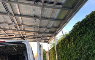 Robustní ocelová konstrukce přístřešku se solárními panely. Pohled zespodu během montáže u zákazníka.