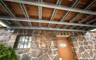 Ocelová konstrukce terasy KOVKOM Nově instalovaná ocelová konstrukce pro terasu nebo přístřešek na kamenném domě. Realizace zakázkové kovovýroby KOVKOM.