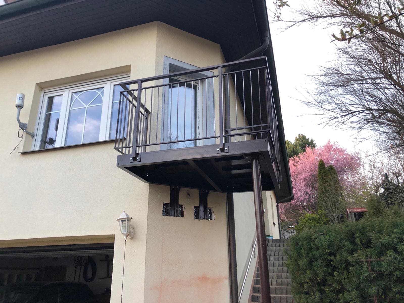 9eb06373-bb95-4022-bb42-0af6a82d7d72 Hotový balkon uchycený na domě s podpěrným sloupem