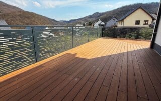 Moderní kovové zábradlí na terasu Designové kovové zábradlí na terasu s perforovaným dekorem a dřevěnou podlahou. Zakázková výroba KOVKOM.