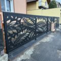 Designový kovový plot s laserem řezaným listovým motivem a samonosná brána s pohonem pro rodinný dům.