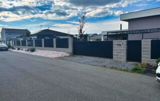 Antracitový plot s plnými dílci a zděnými sloupky pro soukromí, s posuvnou bránou a žárovým zinkem.