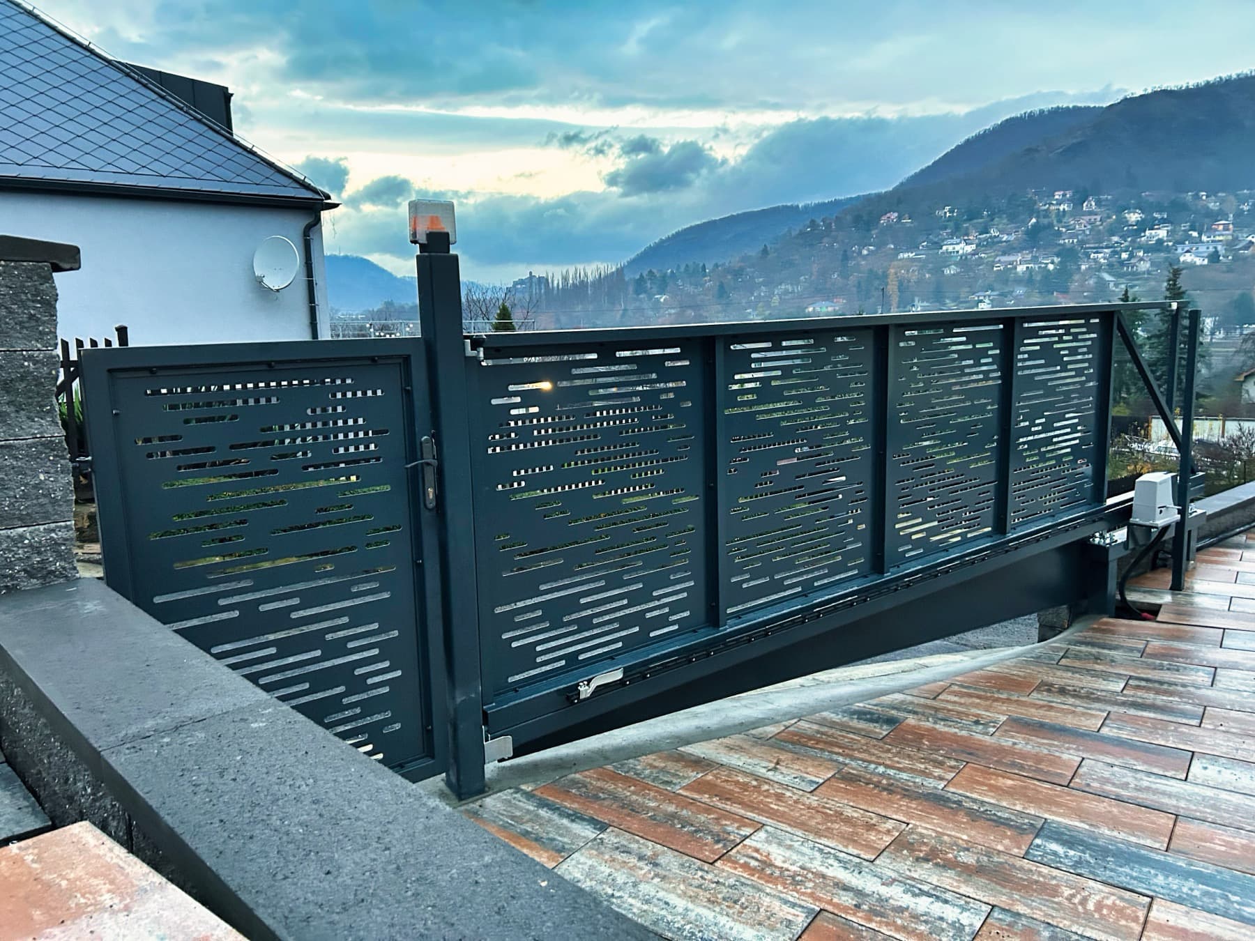 Oplocení a samonosná pojezdová brána s brankou v CNC designu, antracitová, realizace ve svahu